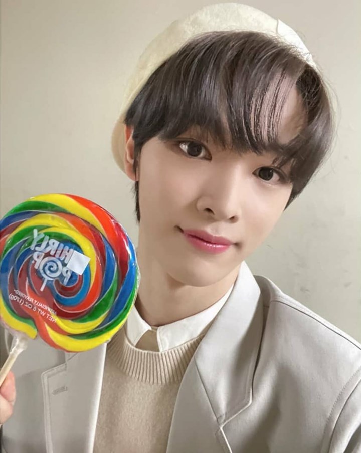 sungchan nct memamerkan lollipop yang ia dapatkan di inkigayo